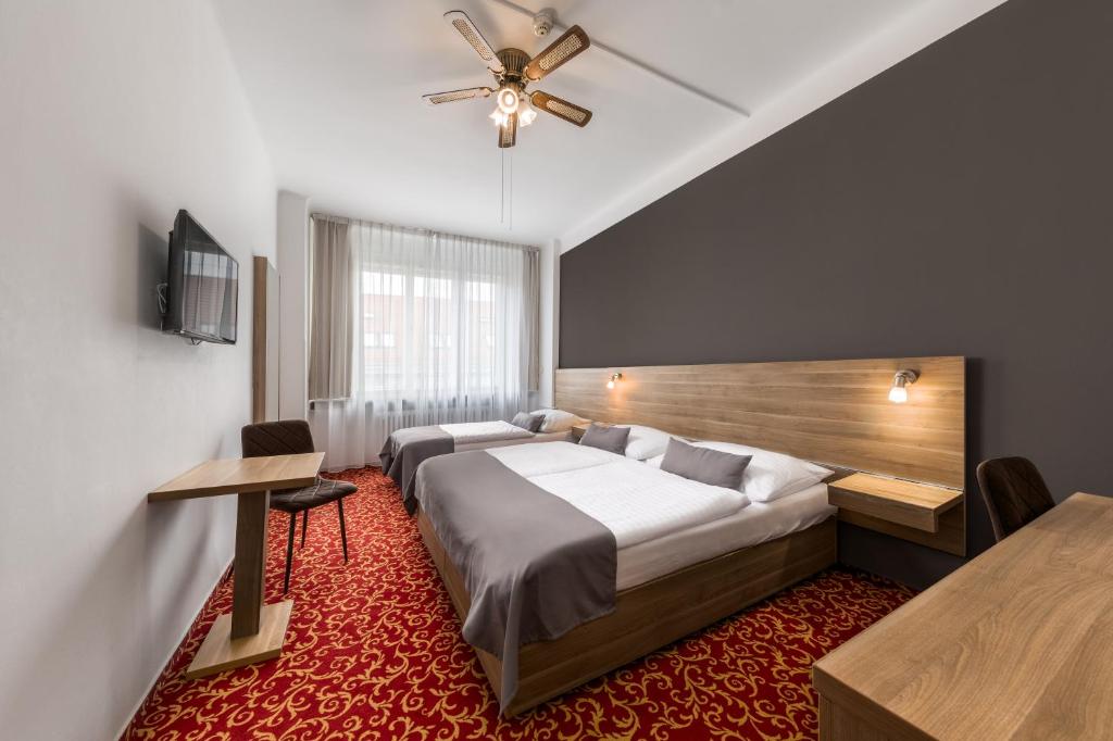 布拉格坎帕梅达博物馆酒店的酒店客房配有两张床和吊扇。
