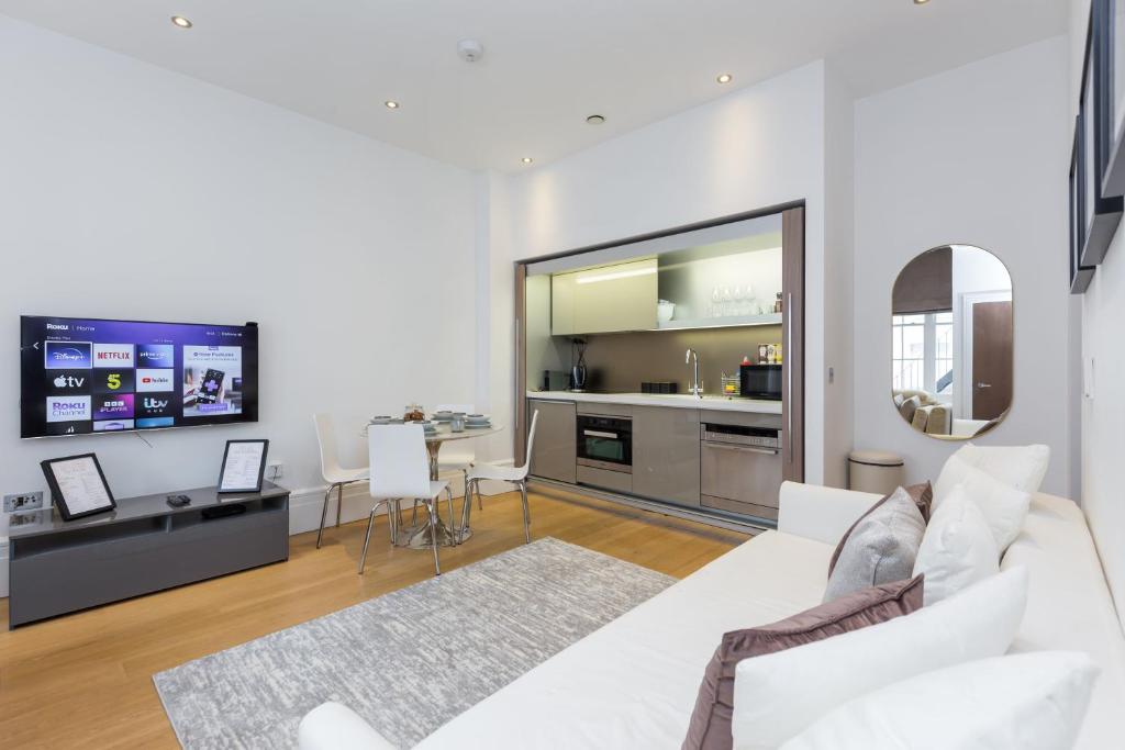 伦敦The Dorset Suite - Stylish New 1 Bedroom Apartment In Marylebone的一间带白色沙发的客厅和一间厨房