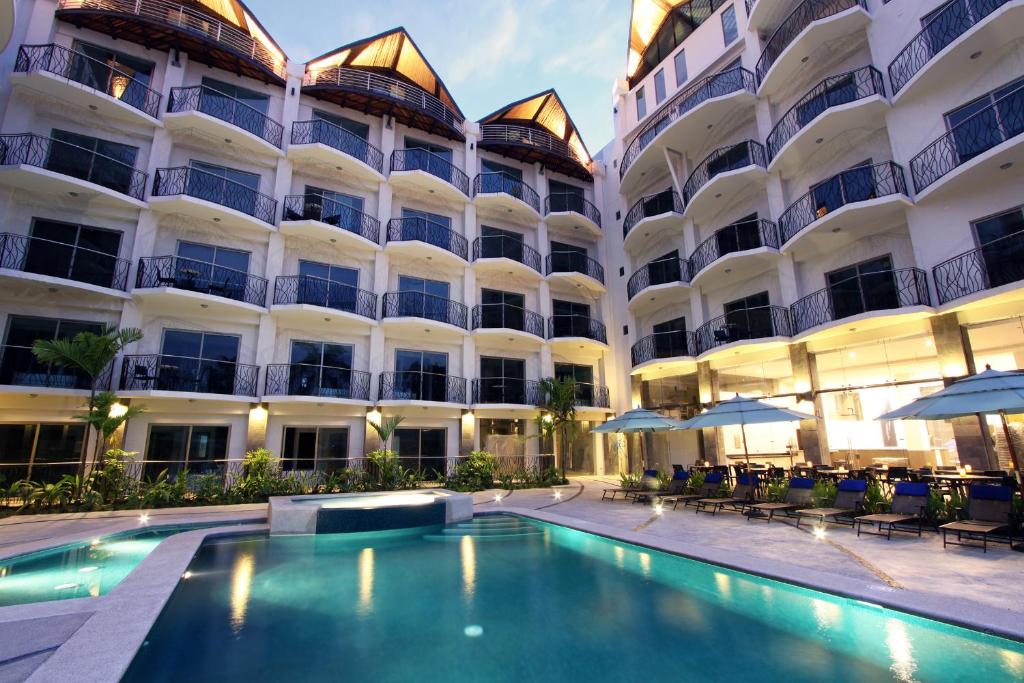 雅科欧神诺精品酒店的大楼前设有游泳池的酒店