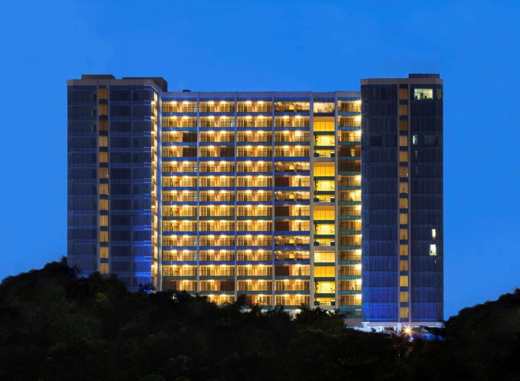 雅加达赫维贝斯韦斯特精品酒店的一座高大的建筑,晚上有灯