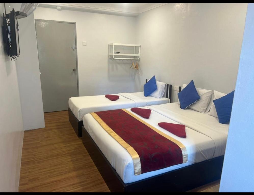 丹那拉打ESM Hotel的两张位于酒店客房的床,配有两张sidx sidx单人床
