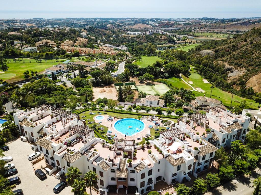 贝纳阿维斯LOS ARQUEROS GOLF APARTMENTS的享有带游泳池的度假村的空中景致