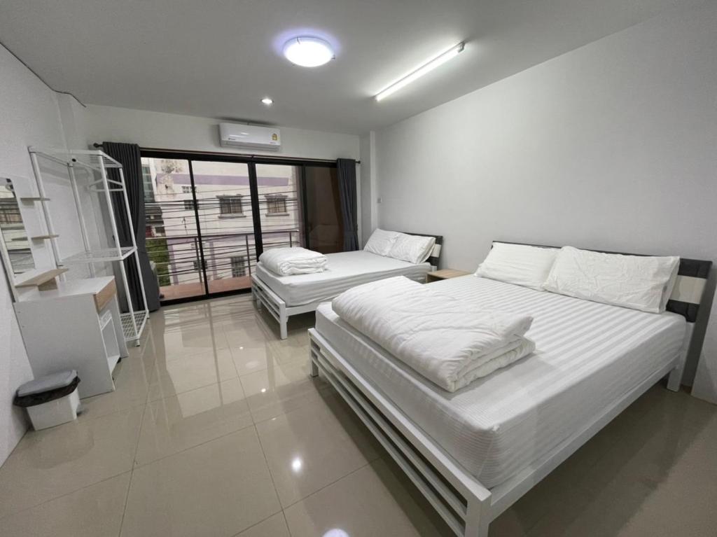 合艾Khoksametchun Hostel Plus 2的一间卧室设有两张床和窗户。