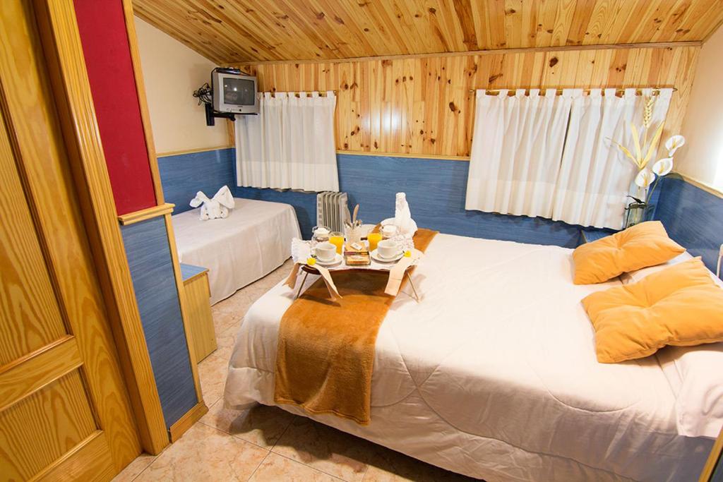 特鲁埃尔埃尔卡特洛旅馆的一间设有两张床和一张桌子的房间