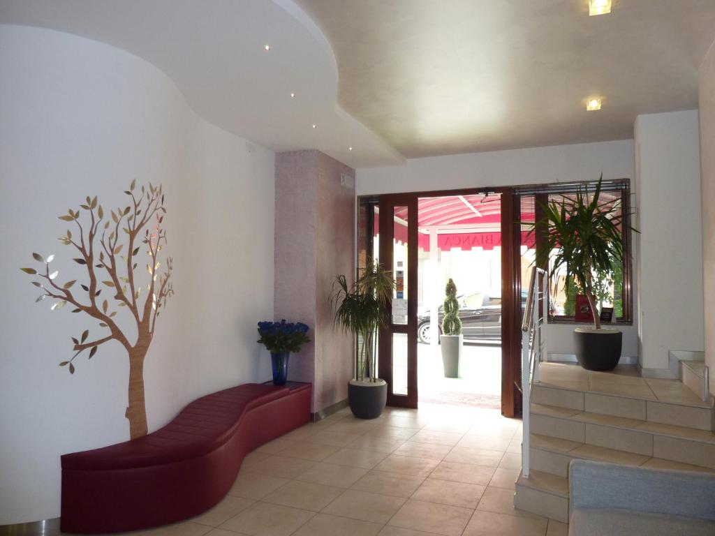 马格拉阿拉比安卡酒店的大堂设有红色的沙发和墙上的树