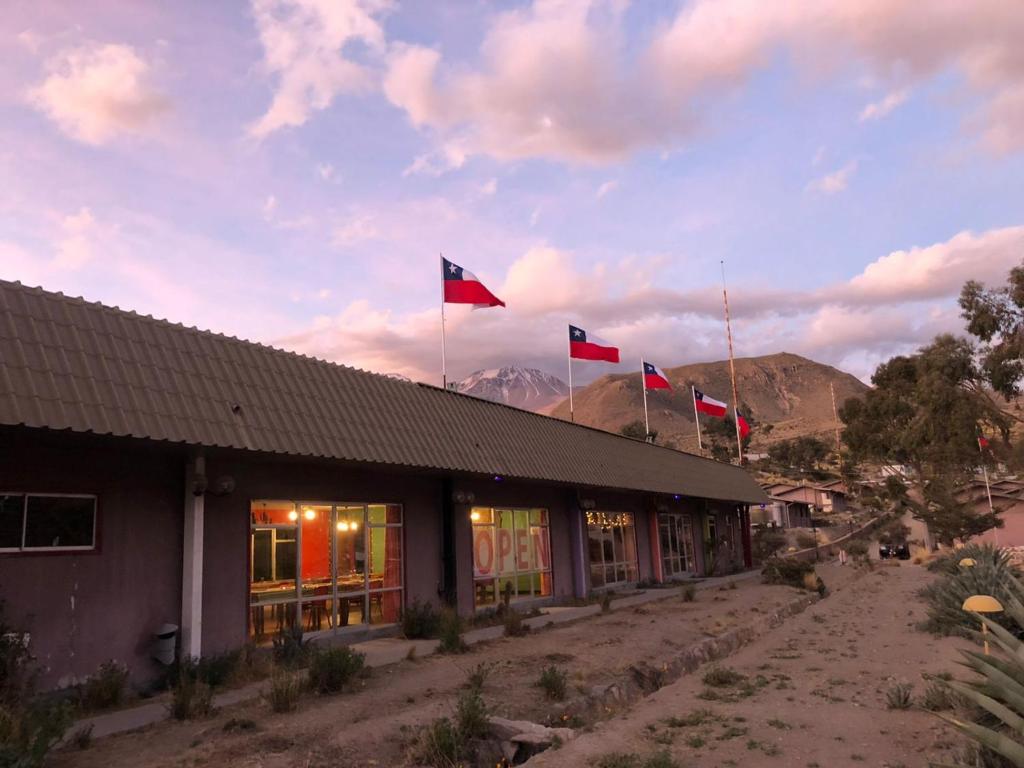 普特雷Hotel Las Vicuñas的上面有三面旗帜的建筑