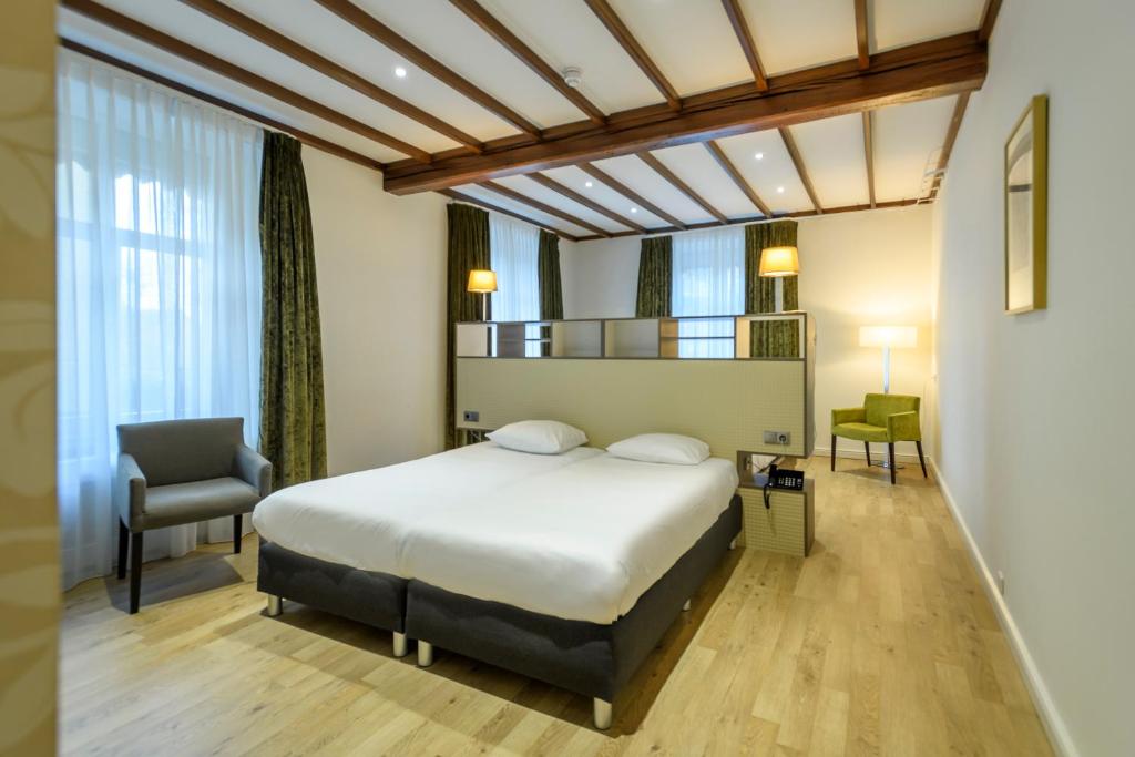法尔肯堡瓦尔肯堡公园酒店的配有一张床和一把椅子的酒店客房