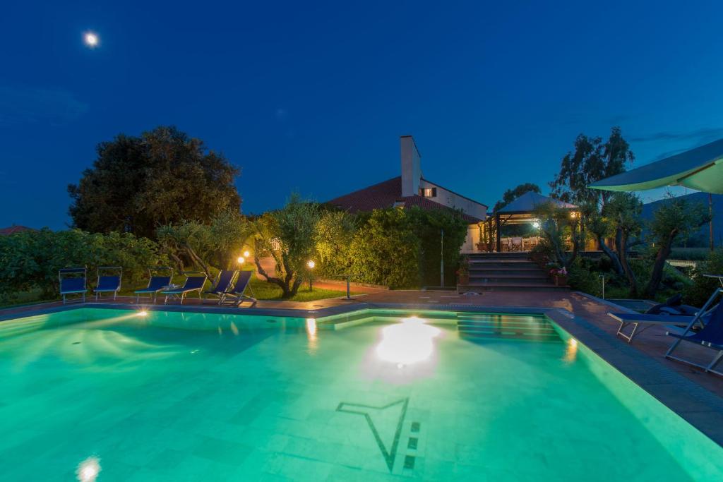 阿梅利亚洛坎达戴拉杰洛酒店的夜间游泳池,配有椅子和灯