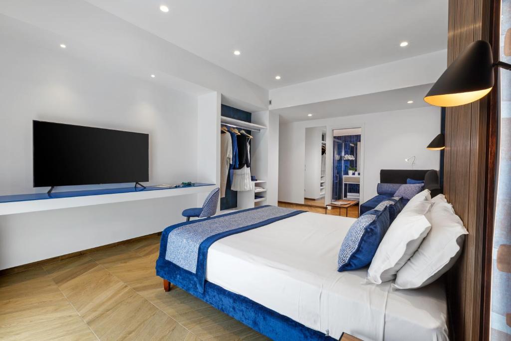 索伦托Dreamers' Rooms Sorrento的一间卧室配有一张大床和一台平面电视
