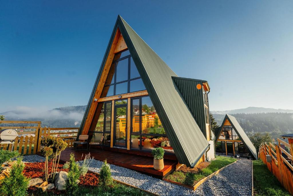 瓦特拉多尔内Krest relaxing heights的一座带玻璃窗户的三角形屋顶的小房子