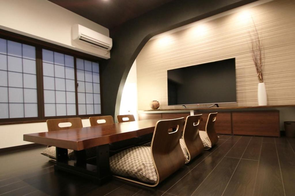 松本Yadoya Matsumoto Honjo - Vacation STAY 13372v的一间会议室,配有桌椅和一台平面电视
