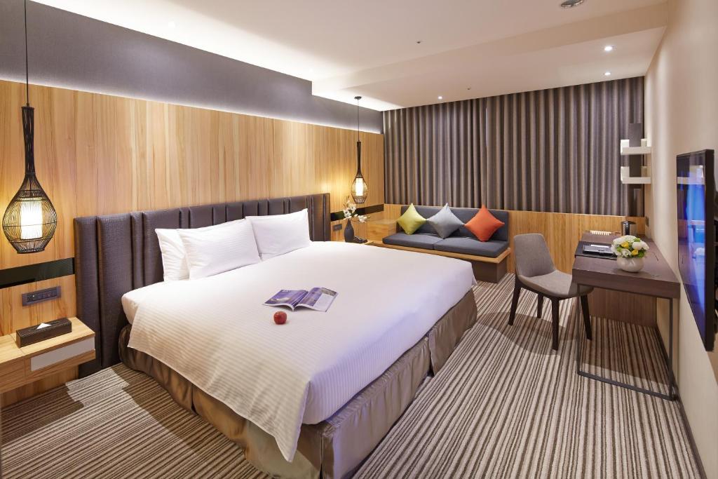 台中市丰邑逢甲商旅的酒店客房设有一张大床和一张书桌。