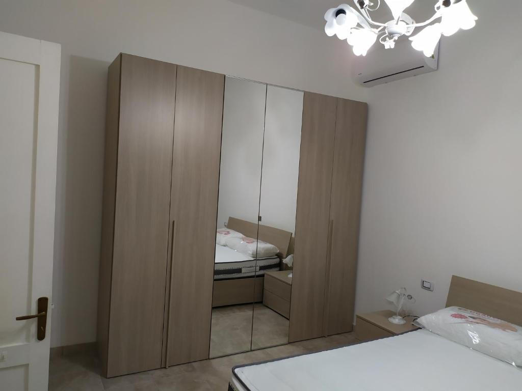 托雷拉皮罗VILLA AURORA 2的一间卧室设有大型木制橱柜和一张床