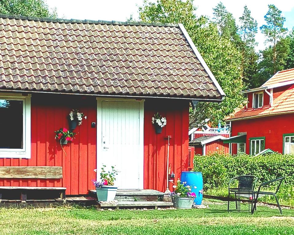 KvillsforsHemma fran Hemma - Stuga的红色的房子,有白色的门和长凳