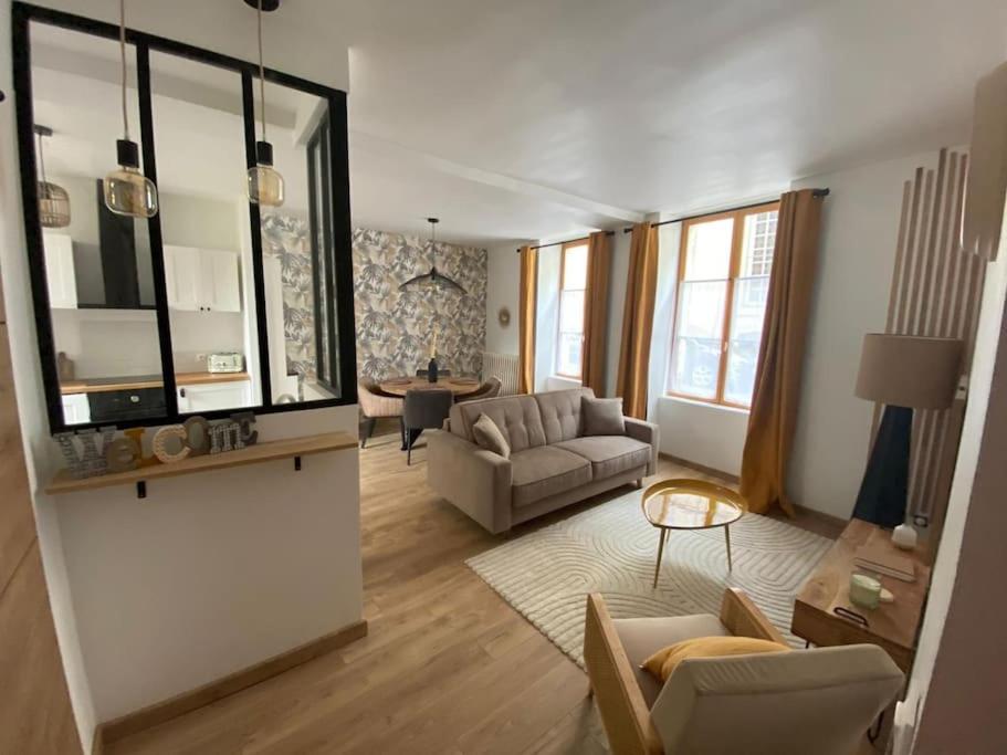 贝莱姆L'Ilot du Perche: Appartement cosy avec jardin的客厅配有沙发和桌子