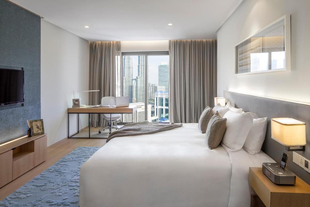 吉隆坡Sfera Residence Kuala Lumpur City Centre的酒店客房设有一张白色大床和一张书桌