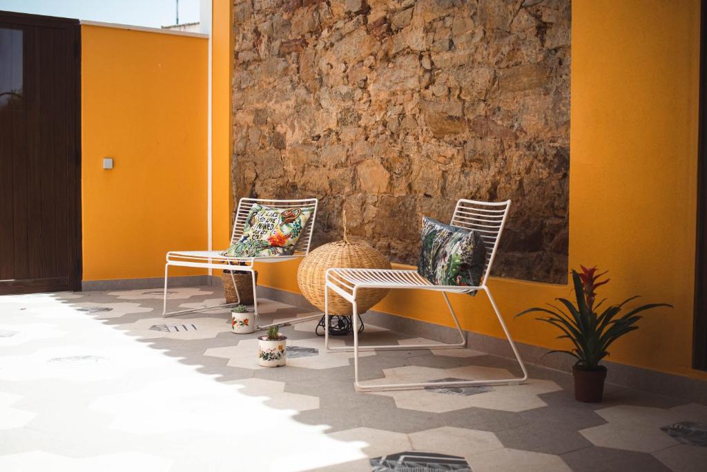 拉波塞拉Laurus - Charming House的两把椅子坐在石墙旁边