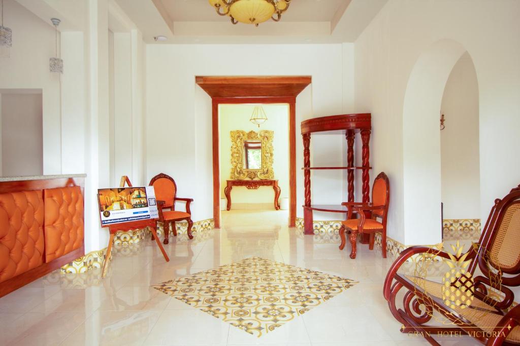 里瓦斯GRAN HOTEL VICTORIA的配有桌椅和镜子的房间