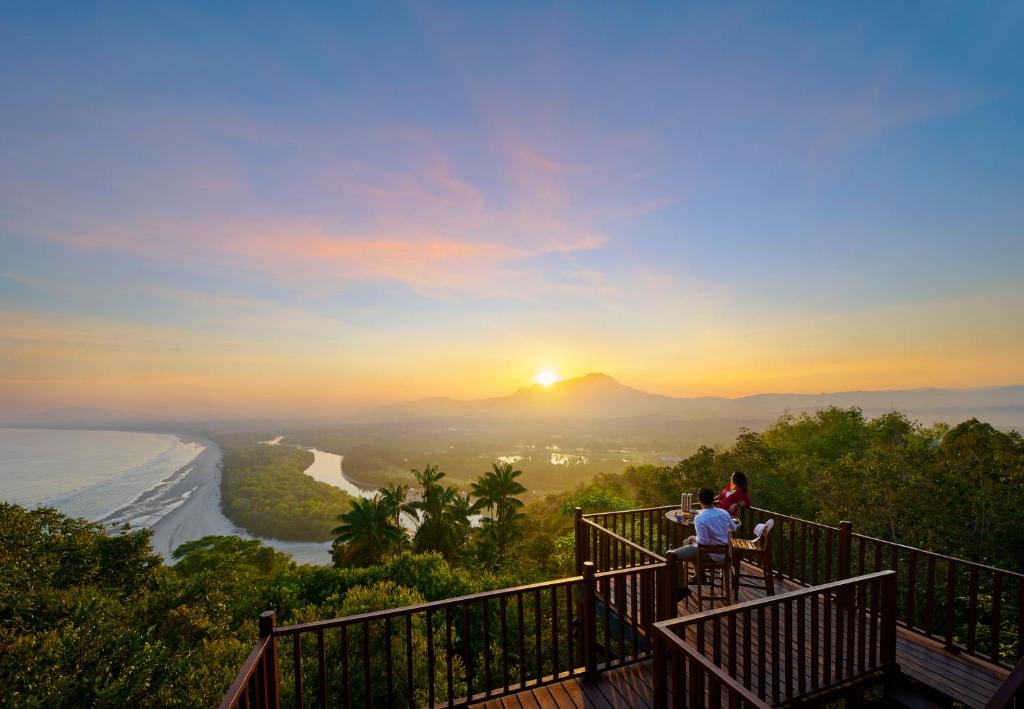 哥打京那巴鲁香格里拉莎利雅度假酒店的一群人坐在观景台上,欣赏日落美景