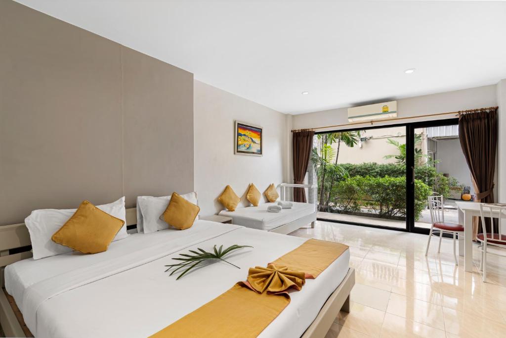 查汶Chaweng Terrace的卧室配有一张带黄色枕头的大型白色床。