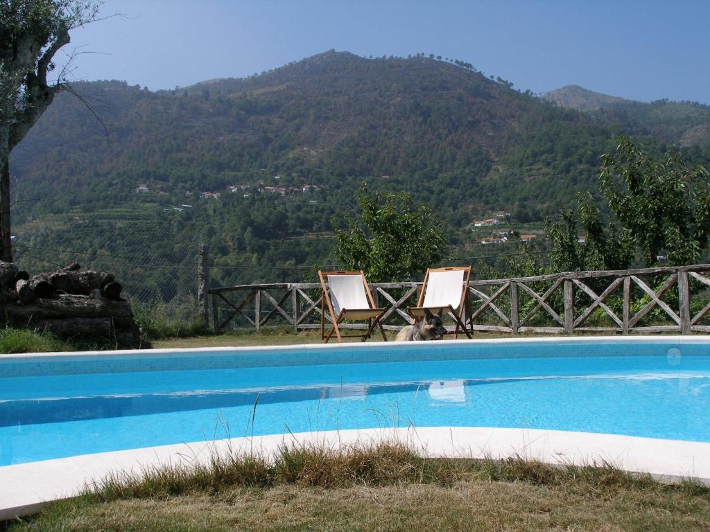 辛方伊什卡萨多莫莱罗酒店的两把椅子坐在一个山地游泳池旁
