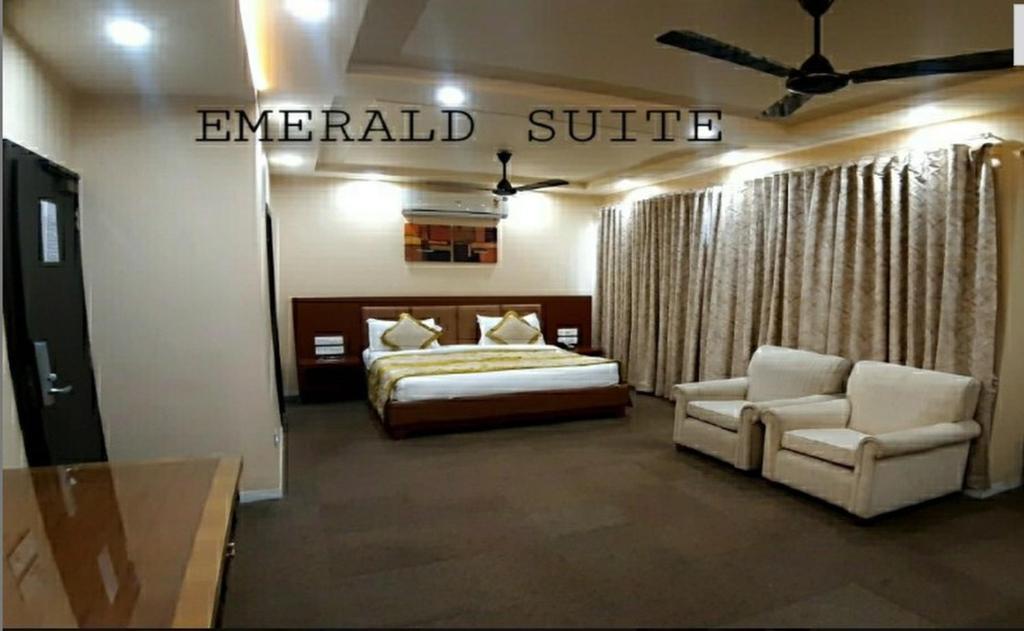 拉杰果德The Emerald Club ,Rajkot的酒店客房,配有床和沙发