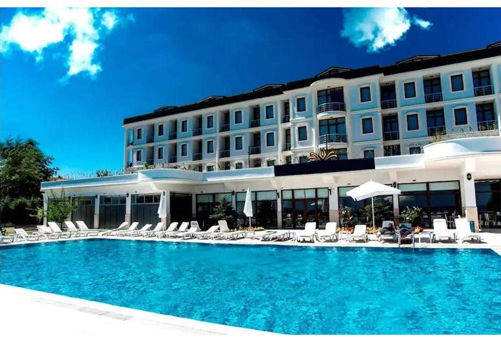 锡利夫里Westport Istanbul Resort & Spa Hotel的一座带游泳池和椅子的酒店和一座建筑