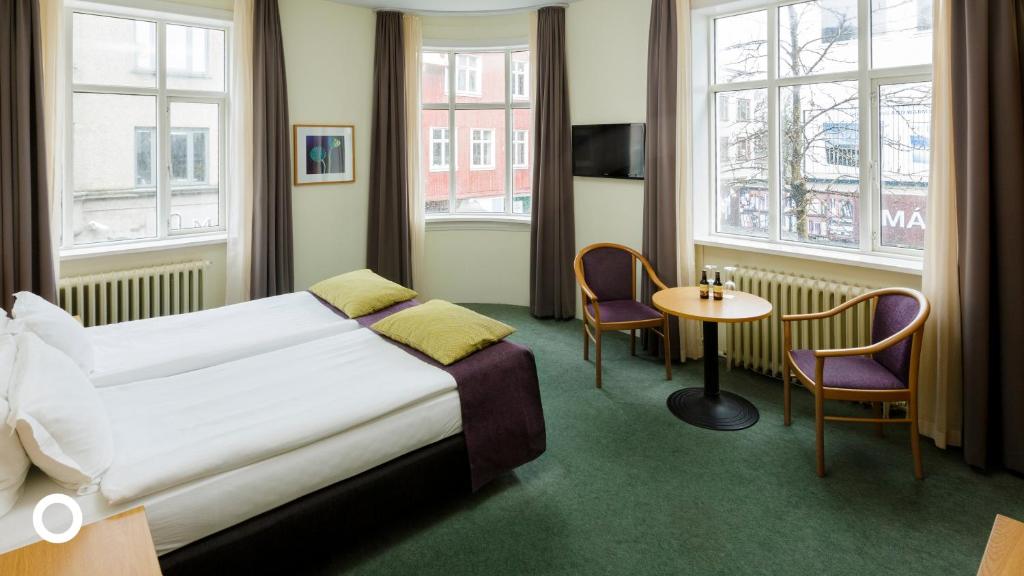 雷克雅未克Center Hotels Skjaldbreid的酒店客房带一张床、一张桌子和椅子