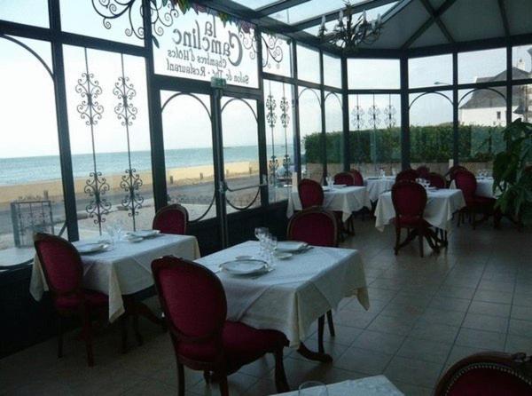 普卢加斯努卡梅林酒店的一间带桌椅和海滩的餐厅