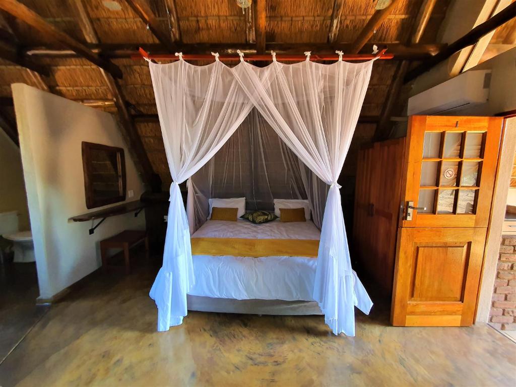 帕拉博鲁瓦Masorini Bush Lodge的一间卧室配有一张带天蓬的床