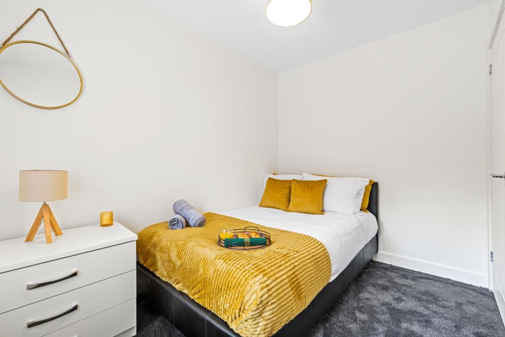 BescotWalsall - 4 Bedroom House, Wi-Fi, Garden , Sleeps 8 - JRR Stays的一间卧室配有一张床和一个带镜子的梳妆台