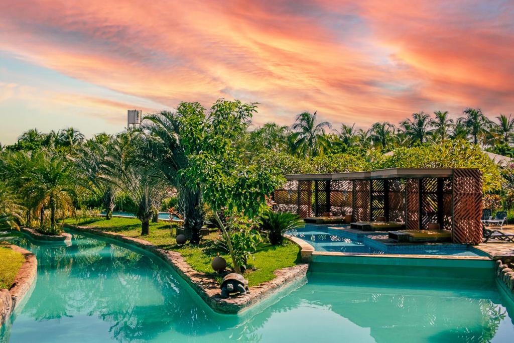 奥林匹亚Hot Beach Resort的一个带游泳池和棕榈树的度假村