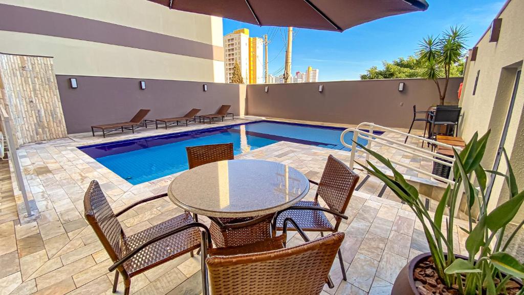 巴乌鲁巴乌鲁舒适酒店的一个带桌椅的庭院和一个游泳池