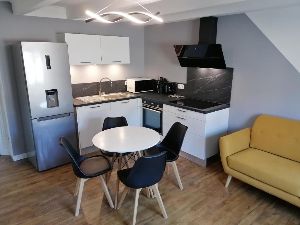 欧里亚克Appartement moderne entièrement rénové的厨房配有桌椅和沙发。