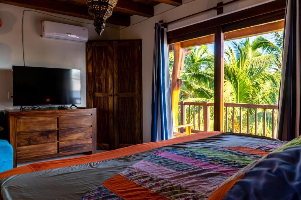 特隆戈内斯Hotel Bajito Bay的一间卧室设有一张床、一台电视和一个窗口。