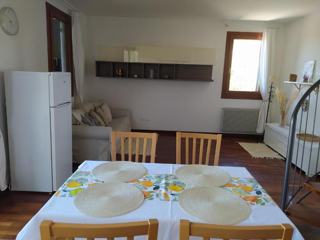 特雷维索L'appartamento Italia B.的厨房配有带四把椅子的桌子和冰箱。