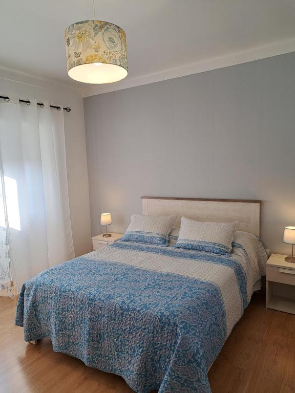 贝雅Beja Garden的一间卧室配有一张带蓝色棉被的床