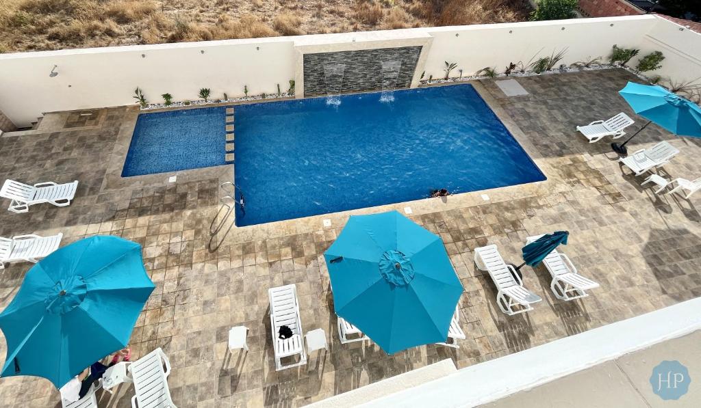 梅克内斯普莱桑斯酒店的享有带椅子和遮阳伞的游泳池的上方景色