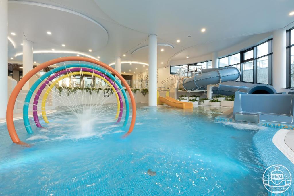 科沃布热格Polanki Aqua - Aquapark - Apartments M&M Kołobrzeg的一座大楼内带水滑梯的游泳池