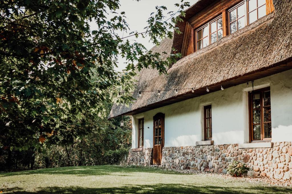 普什奇科沃HOT伊拉尼亚酒店及水疗中心的一座带茅草屋顶的古老石头房子
