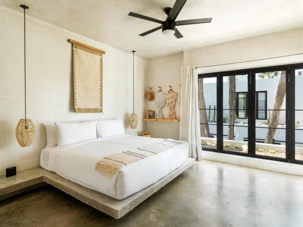 圣何塞德尔卡沃Drift San Jose del Cabo, a Member of Design Hotels的卧室设有白色的床和大窗户