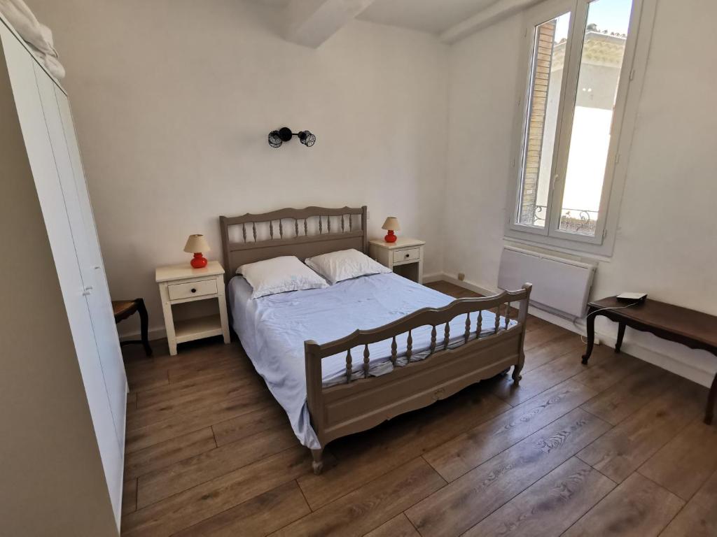 马洛塞讷La suite du beffroi的一间卧室设有床、两张桌子和一扇窗户