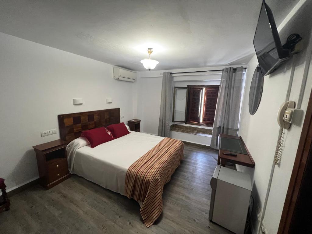 安特克拉科隆安特克拉酒店的一间卧室配有一张床和一台平面电视