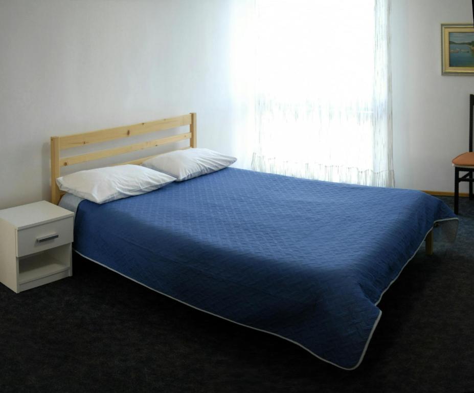 斯普利特Apartments with WiFi Split - 11312的一间卧室配有一张带蓝色毯子的床和窗户。