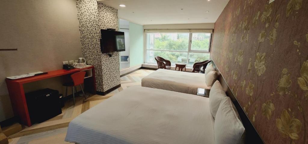 台北喜园旅店的酒店客房设有两张床和电视。