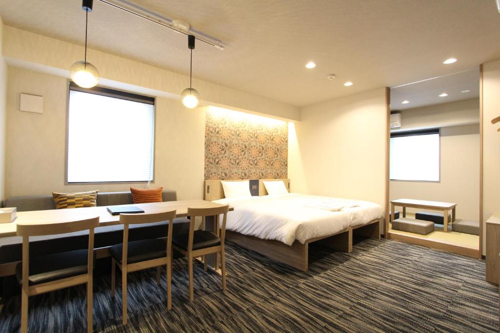 东京KOKO HOTEL Residence Asakusa Tawaramachi的酒店客房带一张床、一张桌子和椅子