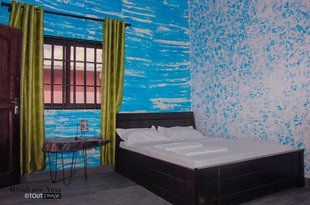 Abomey-CalaviRESIDENCE AINA的一间卧室配有一张壁画床