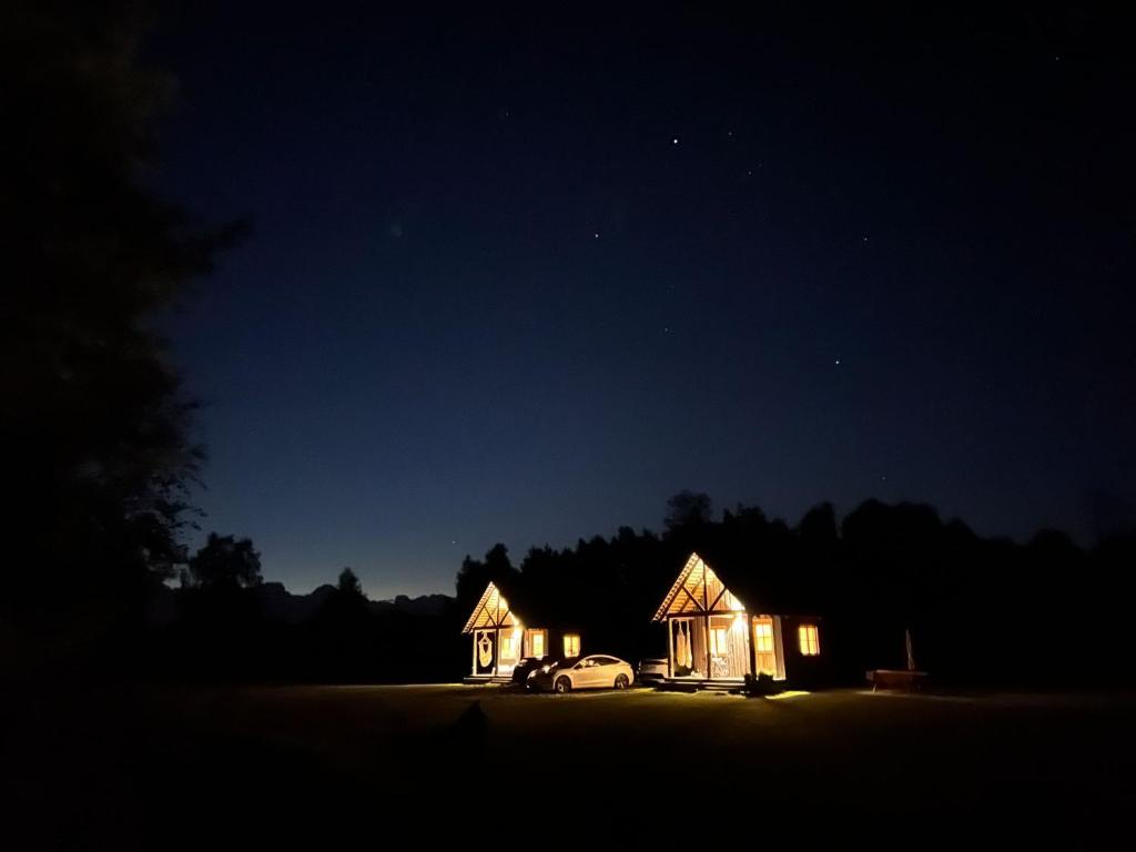 Brīvdienu mājas Lejnieki的夜间的房子,旁边停有一辆汽车