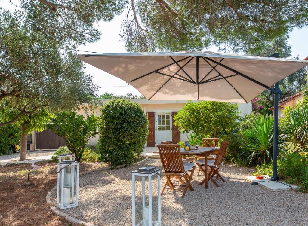 瓦洛里Haus mit Garten über der Bucht von Cannes的大伞下的桌椅