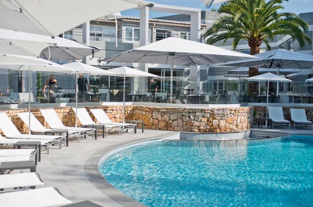 瓦尔邦讷索菲亚安提波利斯金色郁金香spa酒店的一个带躺椅和遮阳伞的游泳池